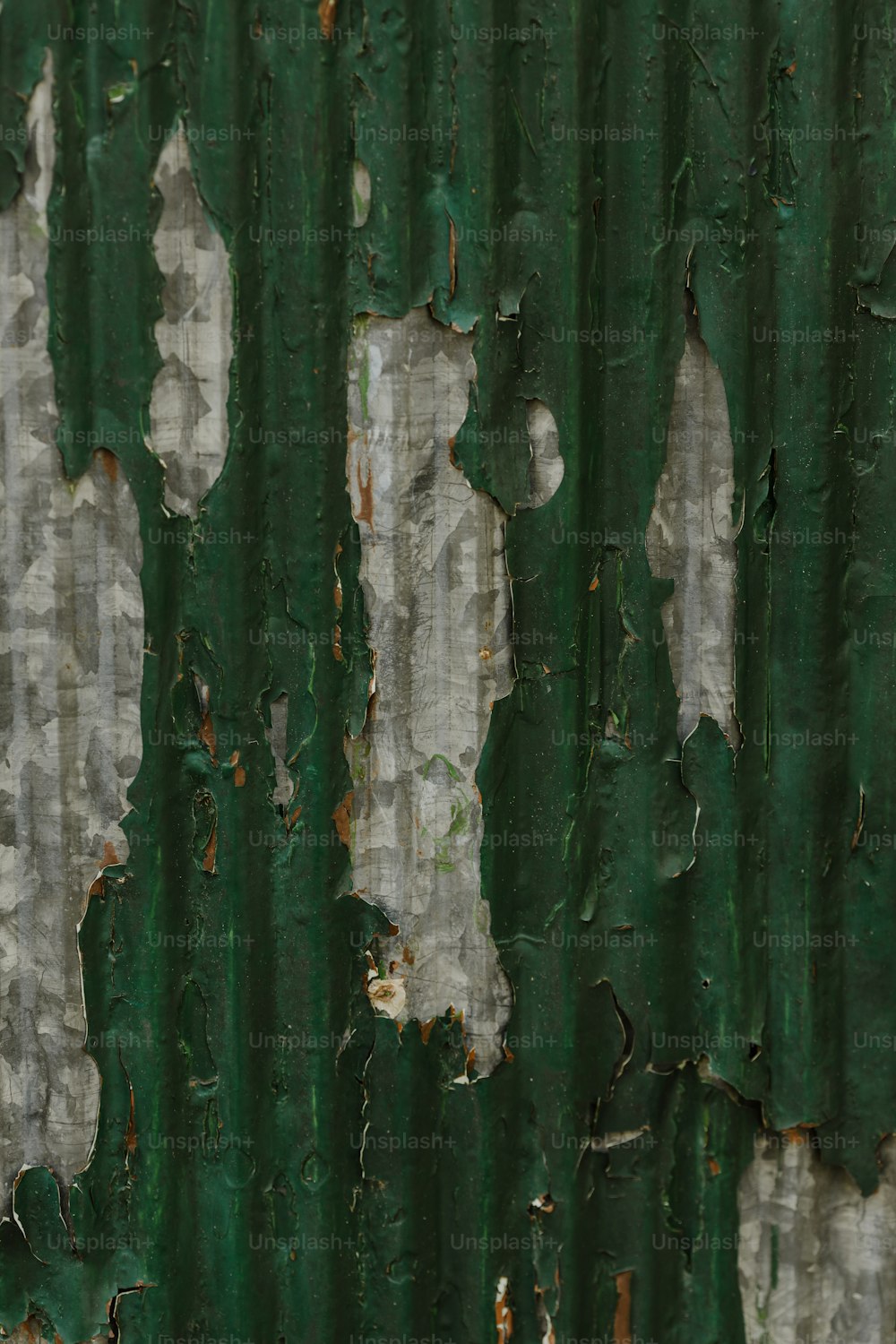 a close up of peeling paint on a green wall