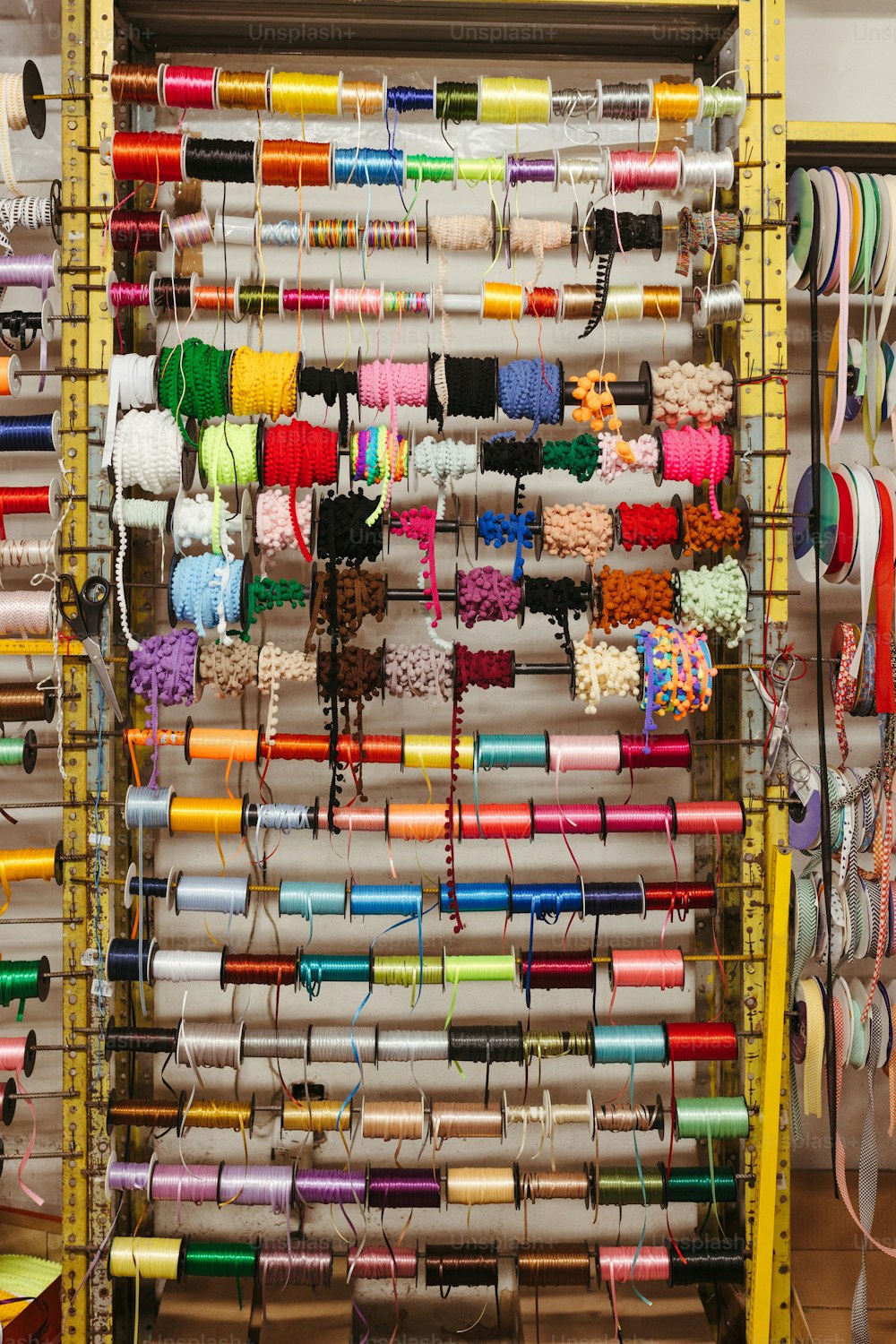um rack de vários carretéis coloridos de linha