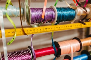 several spools of thread are hanging on a wall