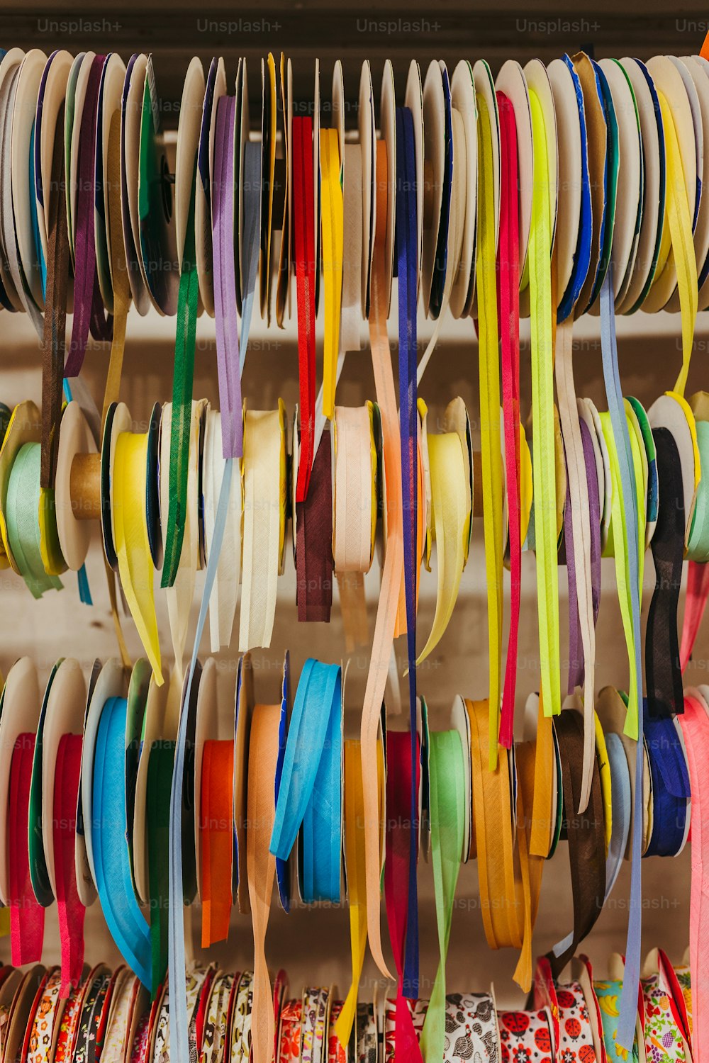 a bunch of different colored ribbons hanging on a wall