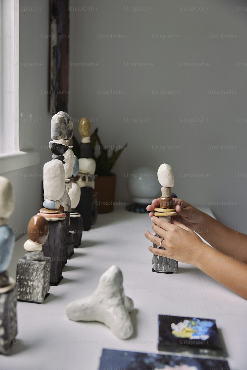 a person is holding a small bottle in front of a row of small figuri