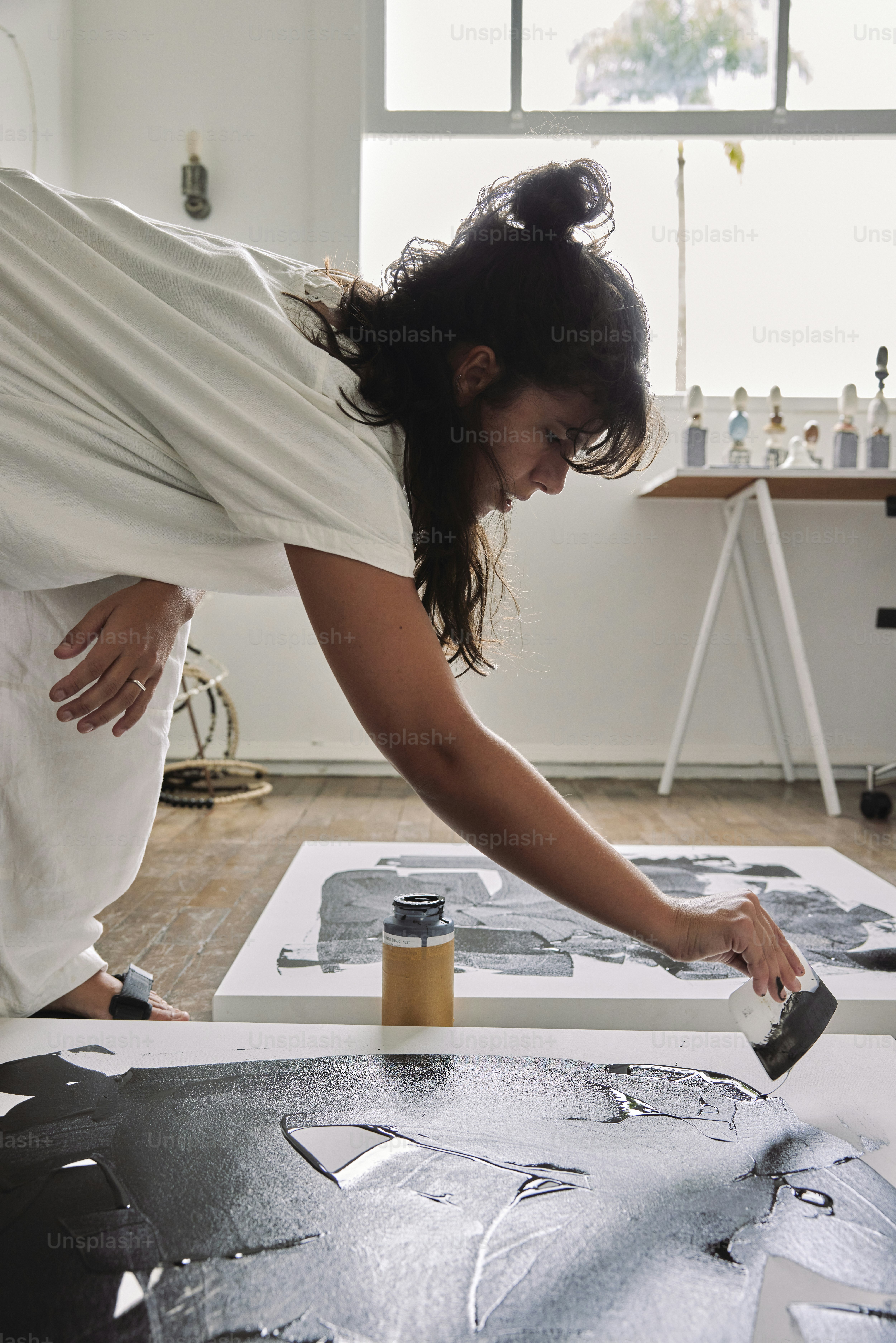 a woman is working on a piece of art