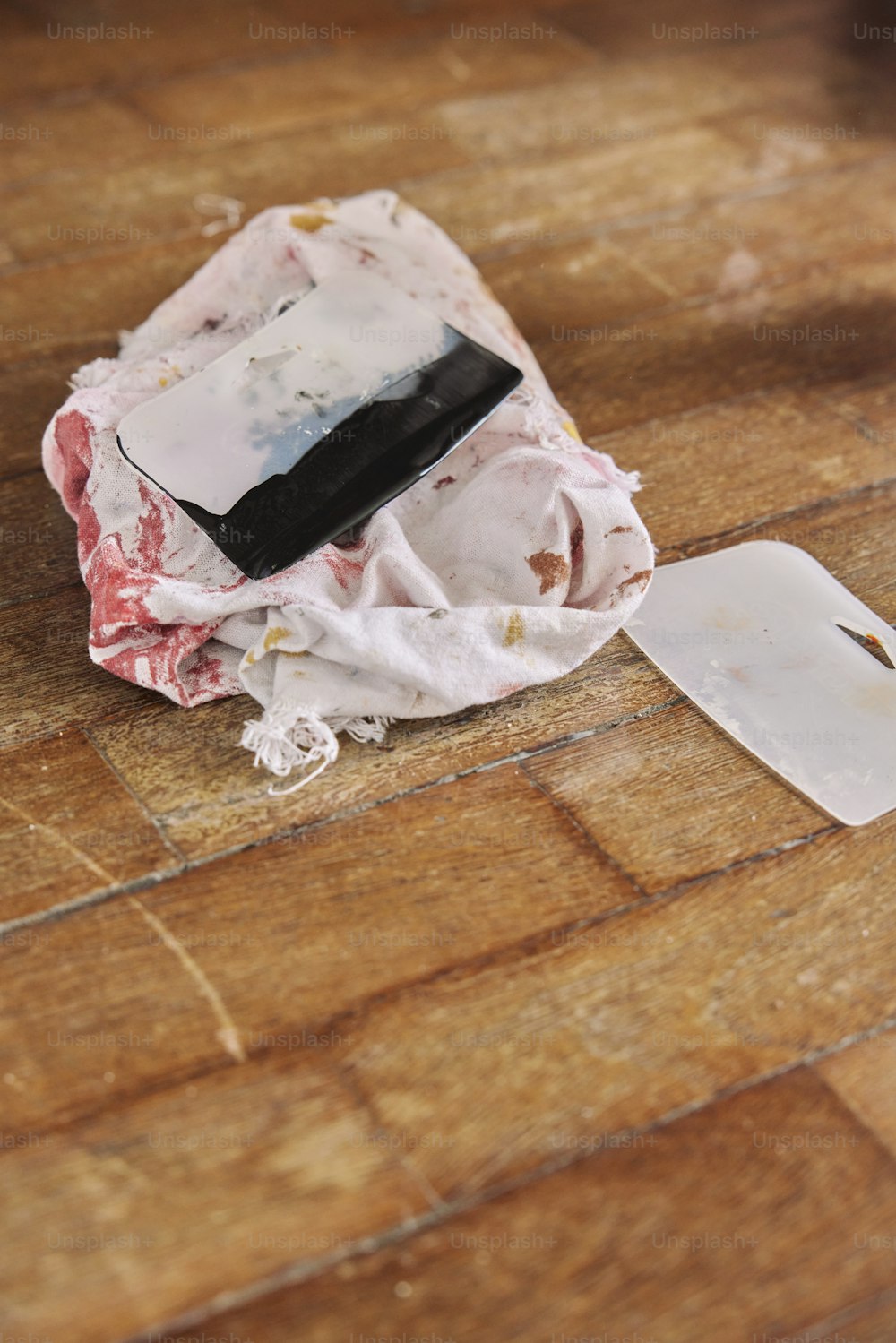 a cell phone laying on top of a wooden floor