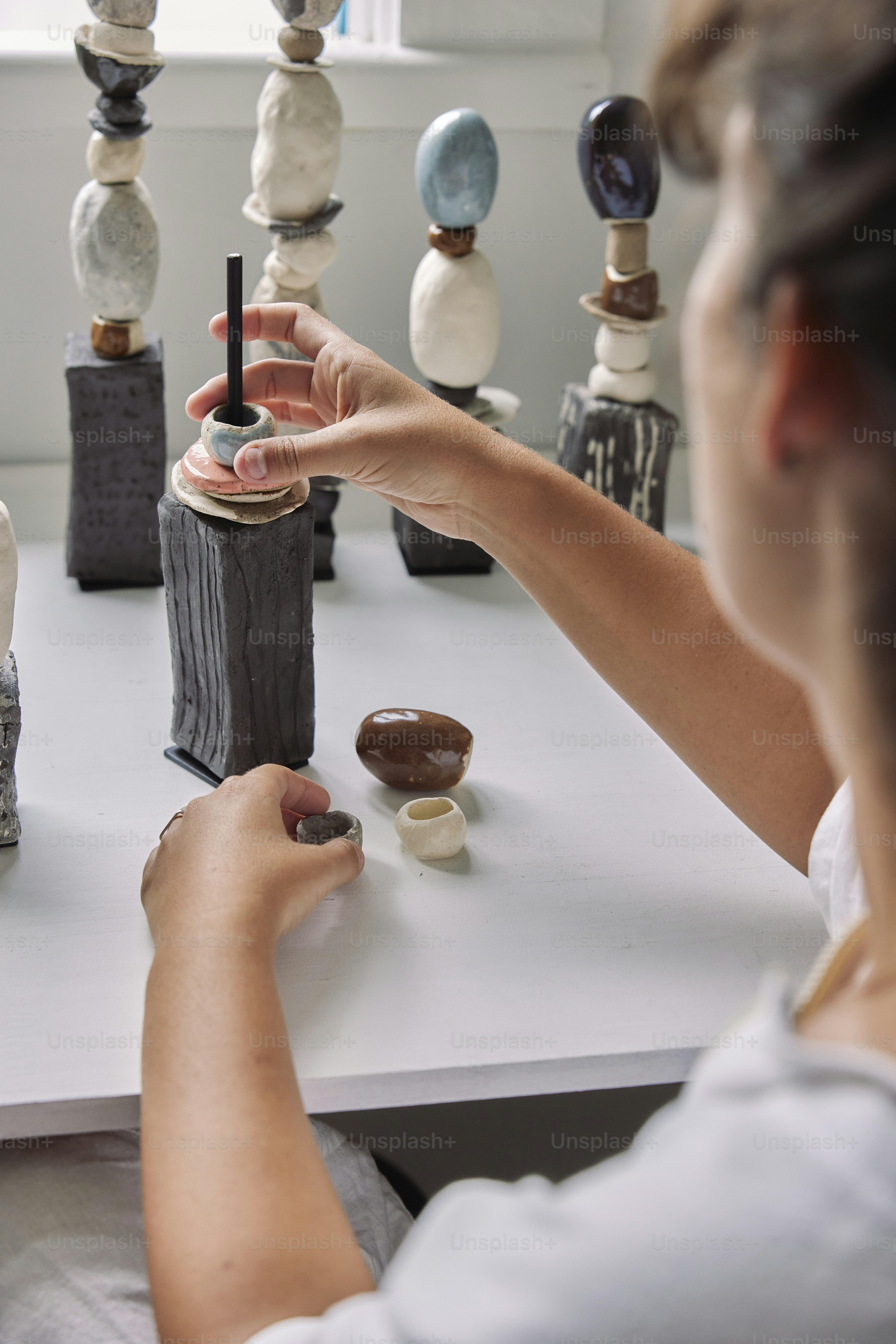 una donna seduta a un tavolo che lavora su una scultura