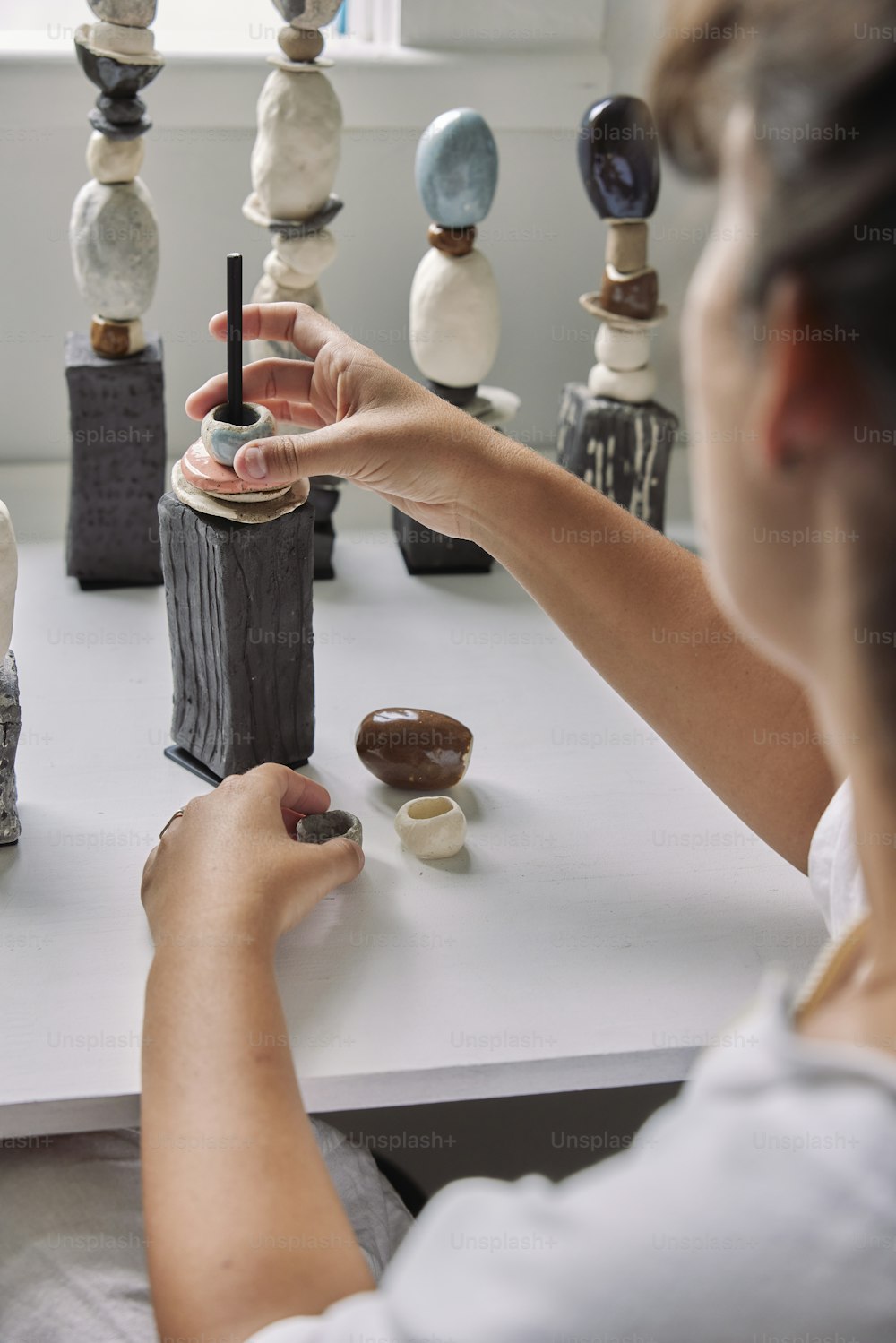 una donna seduta a un tavolo che lavora su una scultura