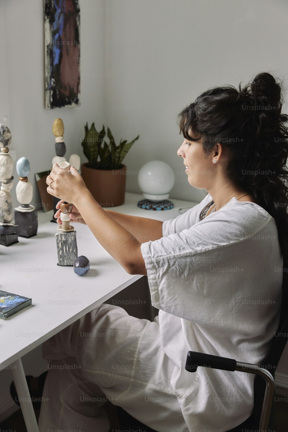 a woman sitting at a desk with a vase