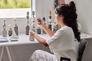 a woman sitting at a table with a bunch of figurines on it