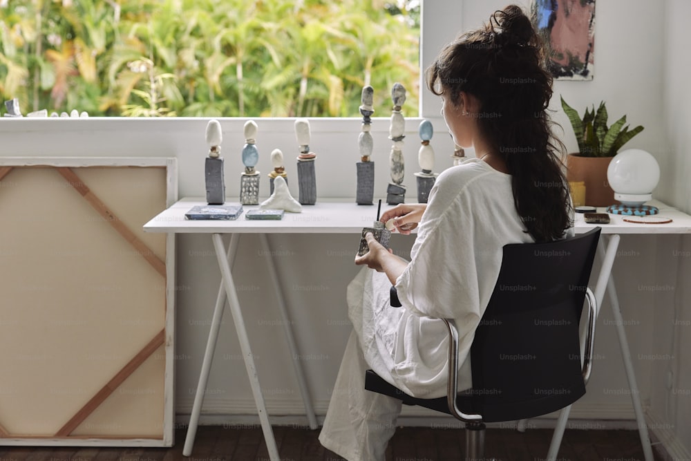 a woman sitting in a chair looking at a cell phone