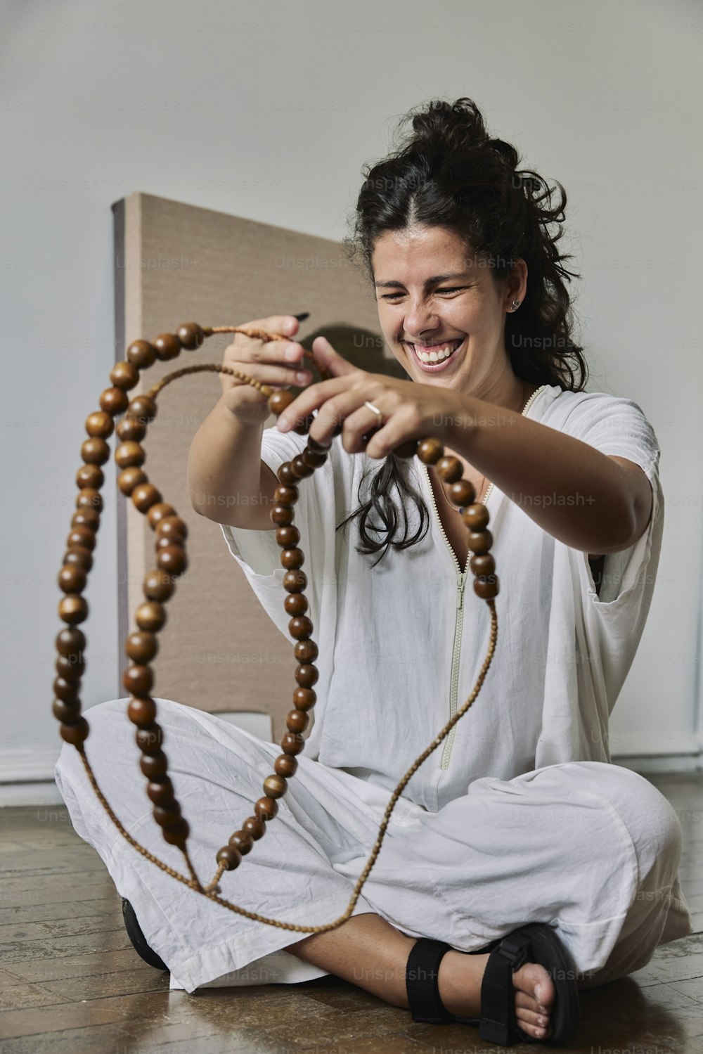 a woman sitting on the floor holding a rosary