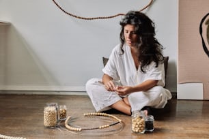 a woman sitting on the floor surrounded by beads