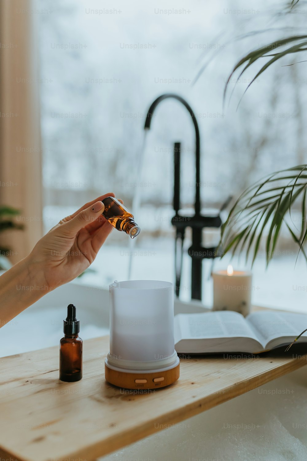 a person holding a small bottle of essential oils