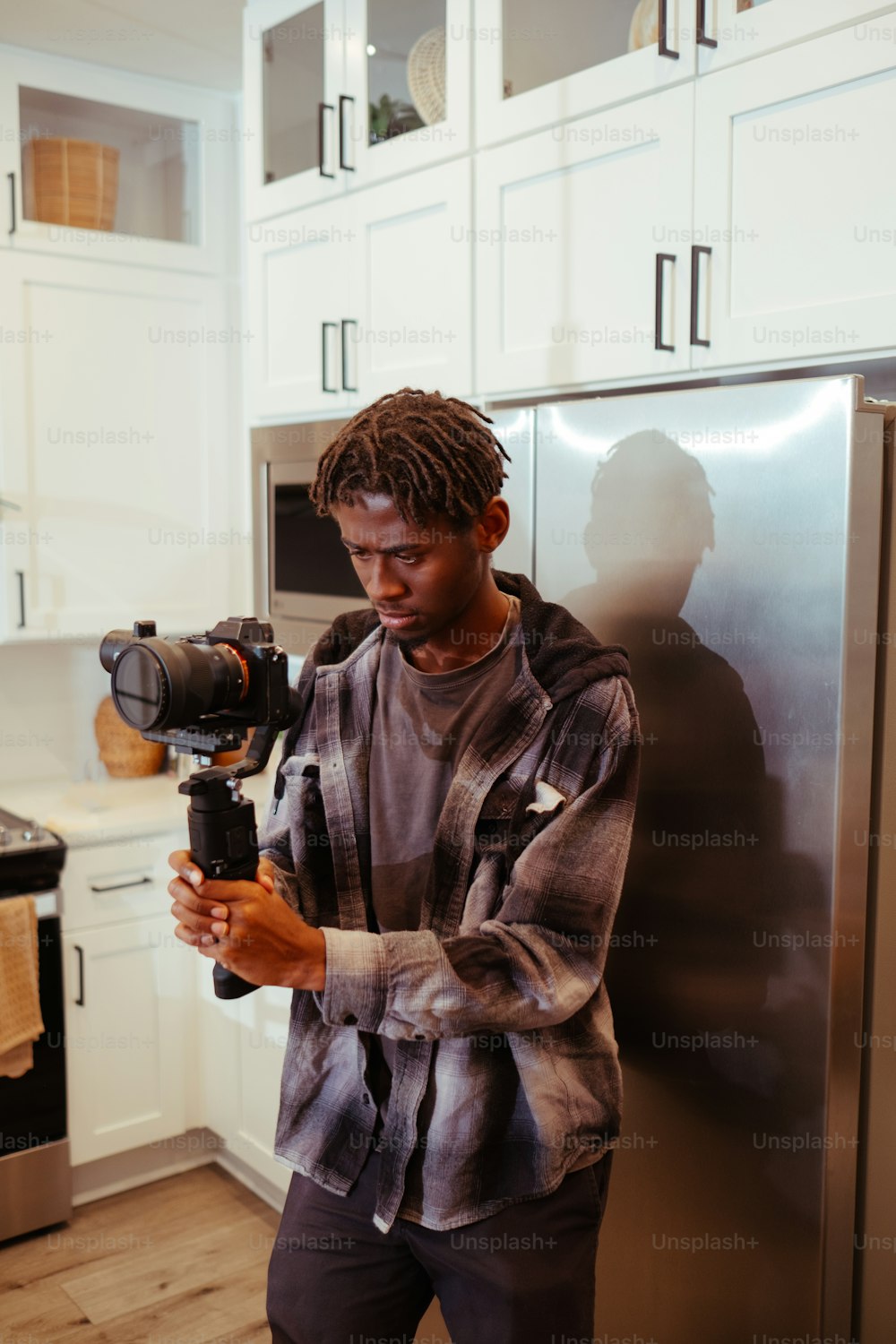 Un uomo che tiene una macchina fotografica in una cucina