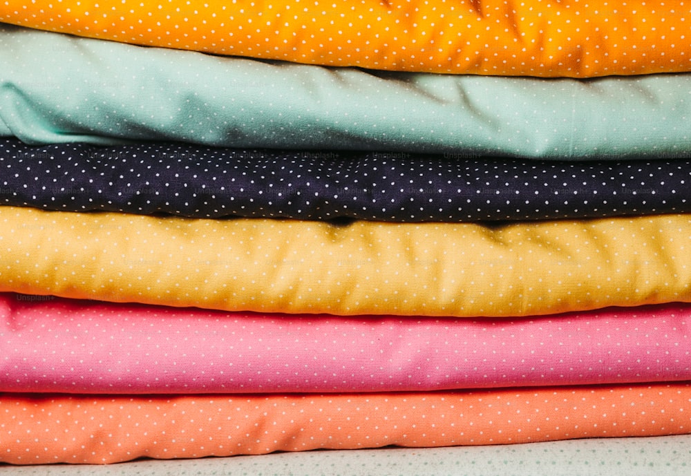 a stack of different colored fabrics sitting on top of each other