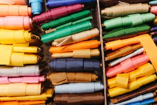 Une boîte remplie de nombreux rubans de couleurs différentes