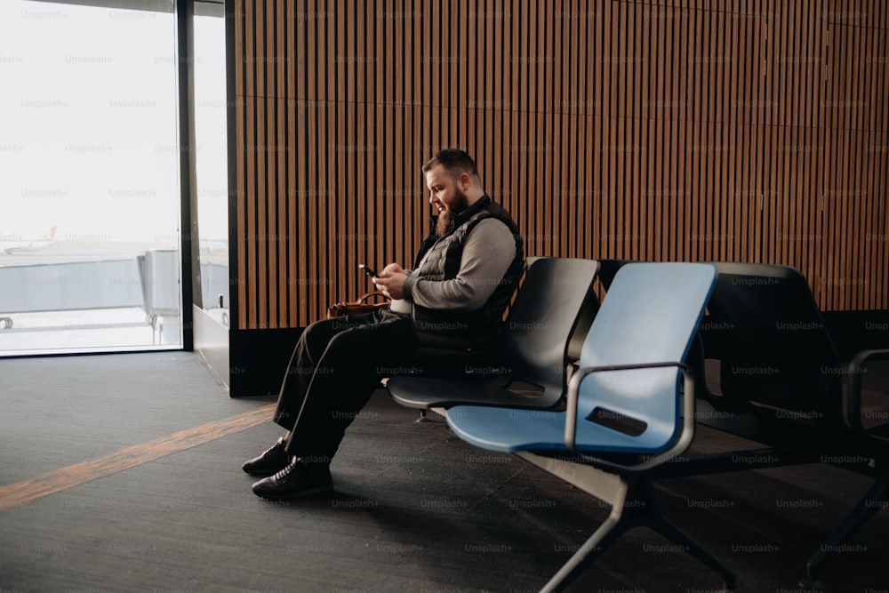 Ein Mann sitzt auf einer Bank in einem Flughafen
