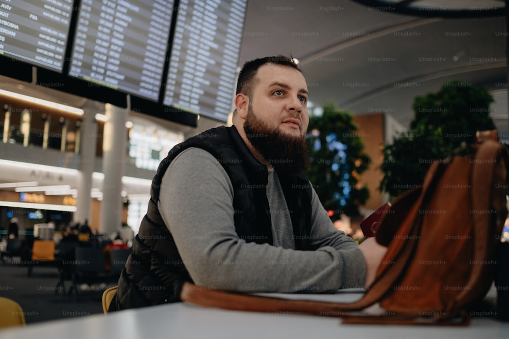 Ein Mann sitzt an einem Tisch in einem Flughafen