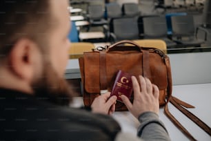 Un uomo ha in mano un passaporto e una borsa