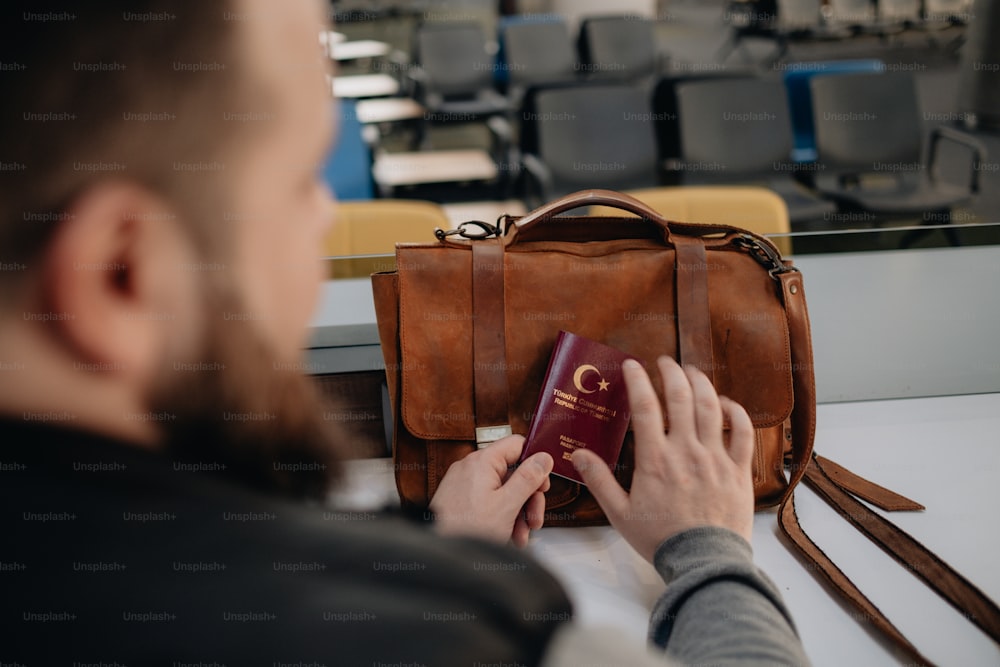 한 남자가 여권과 가방을 들고 있다