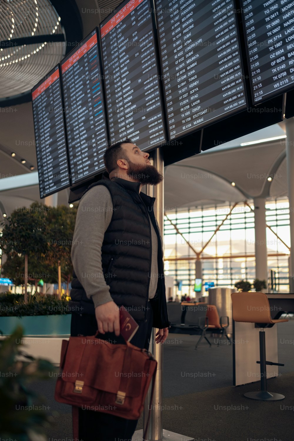 Un hombre con barba de pie junto a un letrero