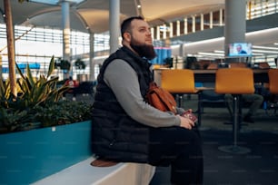 a man sitting on a bench in an airport