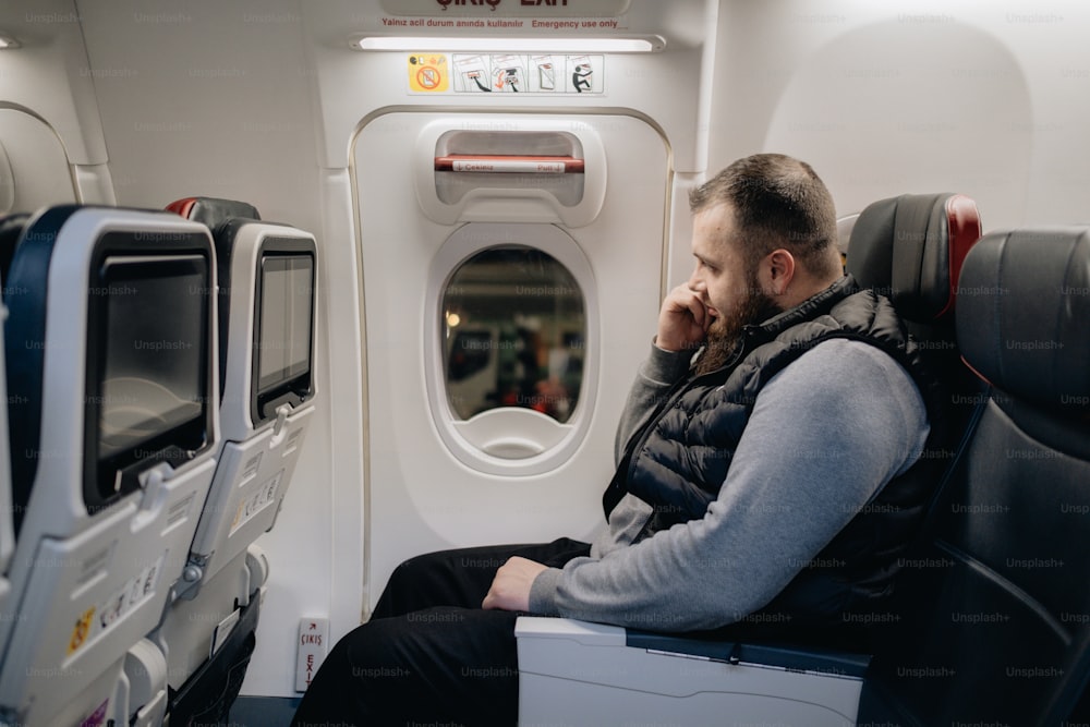 Ein Mann sitzt in einem Flugzeug und schaut aus dem Fenster