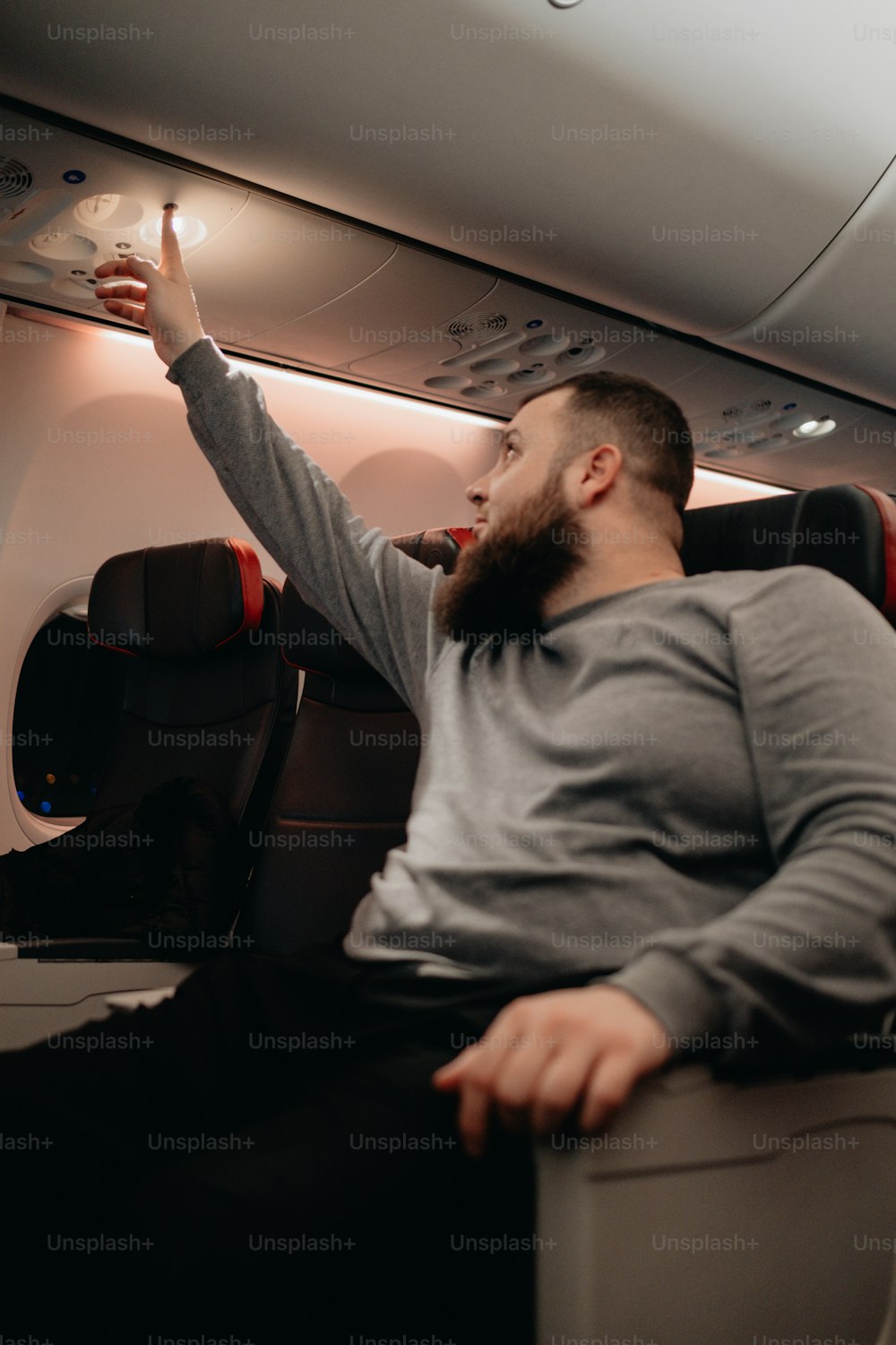 a man with a beard sitting on an airplane