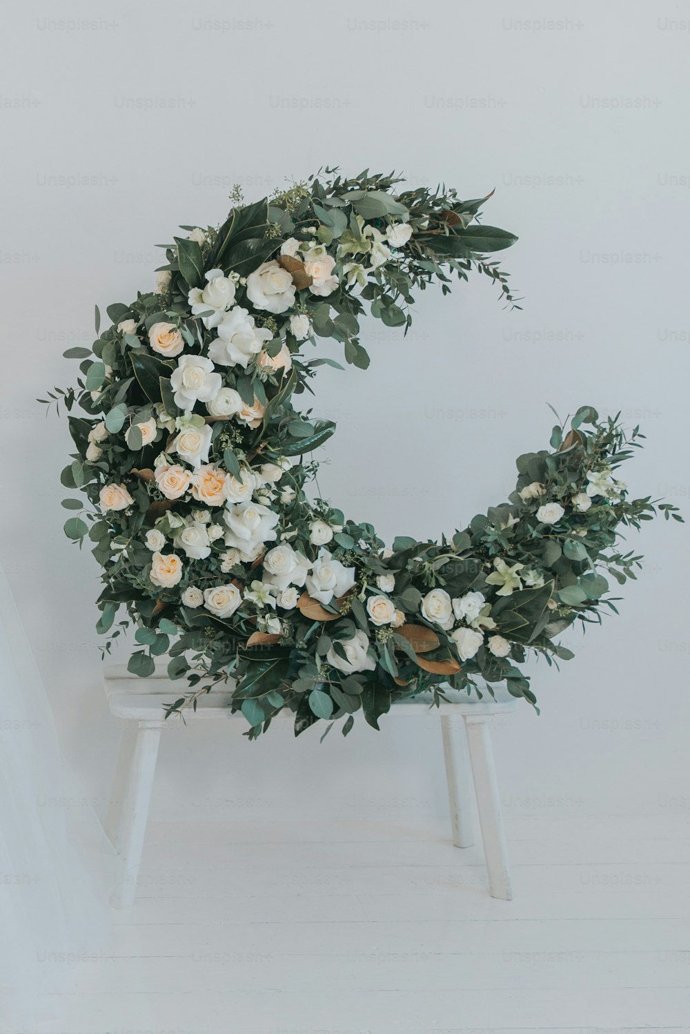 Una corona di fiori bianchi su una sedia bianca