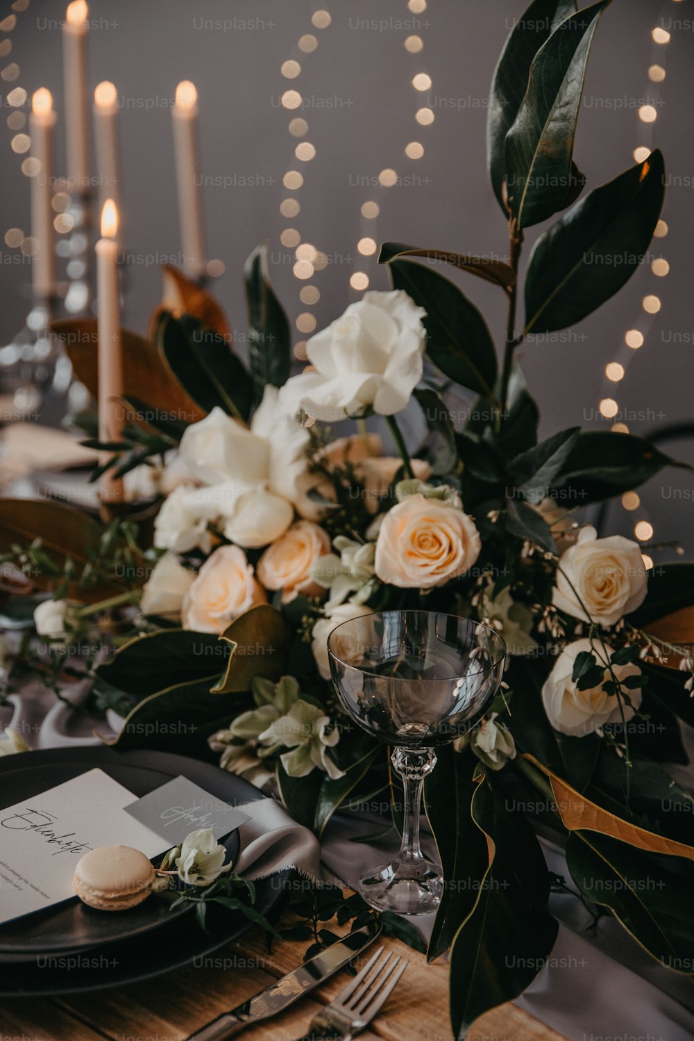 a table set for a formal dinner with candles and flowers