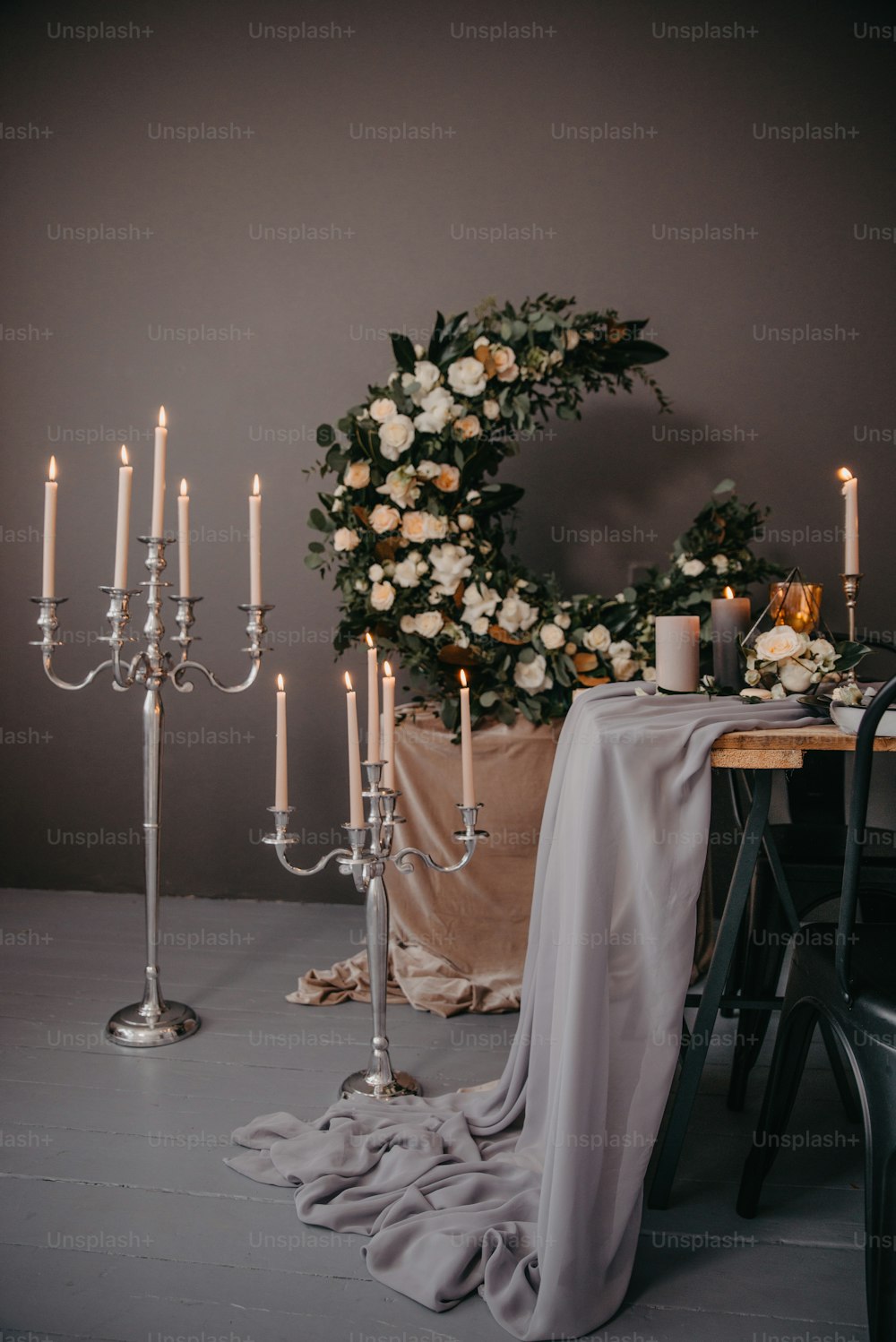 una mesa con velas y una corona de flores