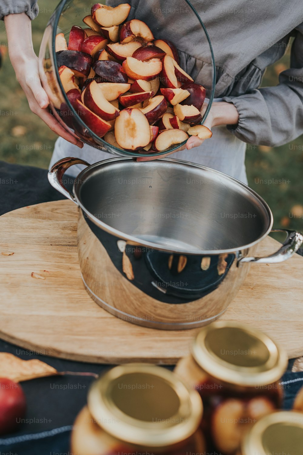 a woman holding a bowl of sliced apples