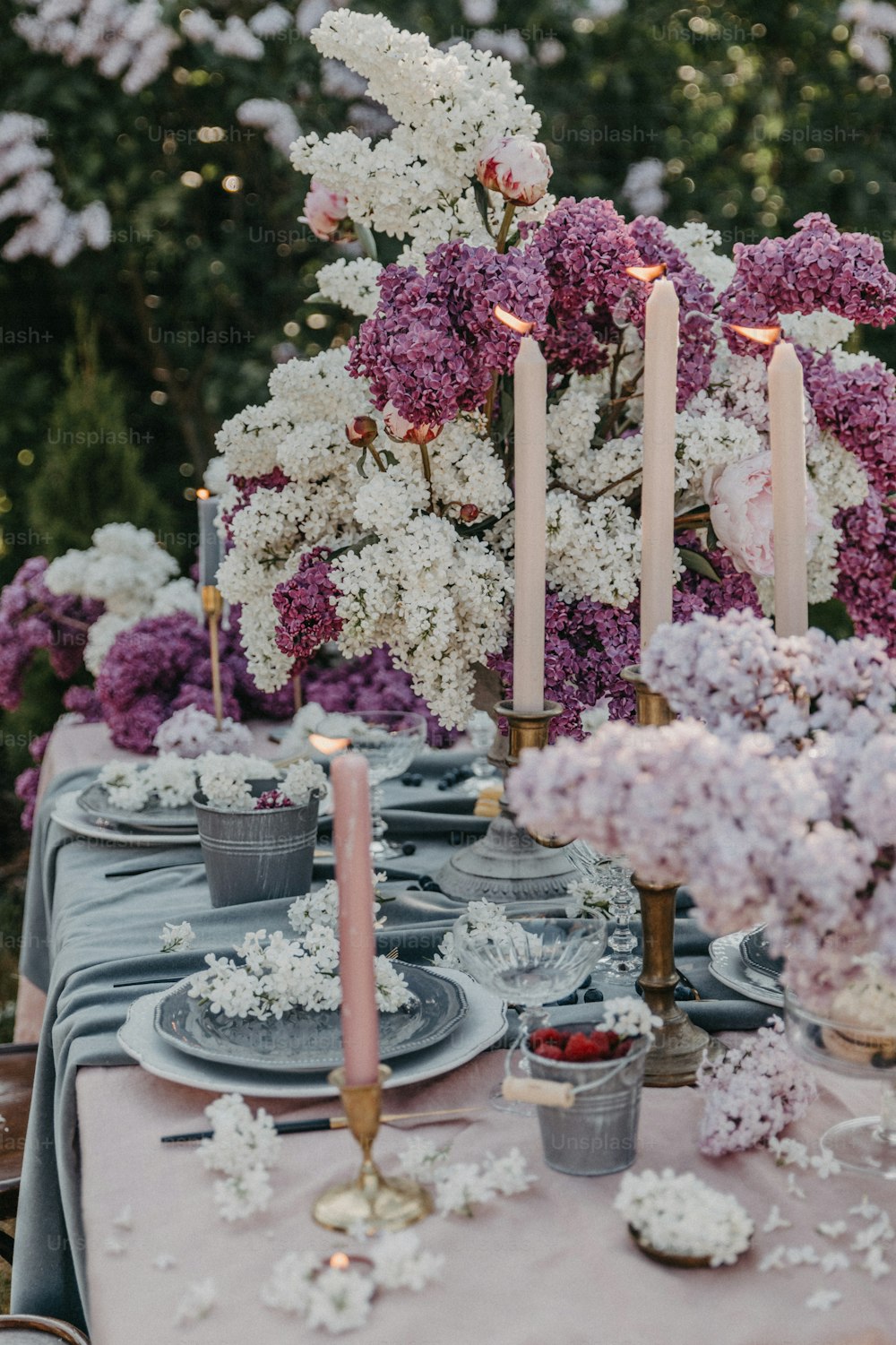 Una mesa cubierta con muchas flores moradas y blancas