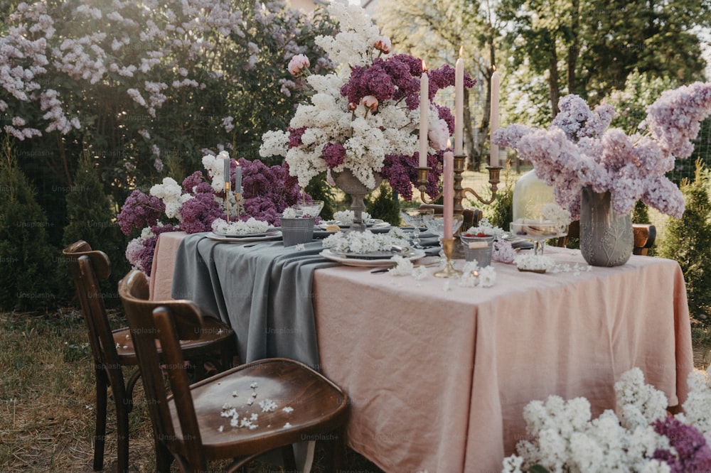 Une table est dressée avec des fleurs et des assiettes
