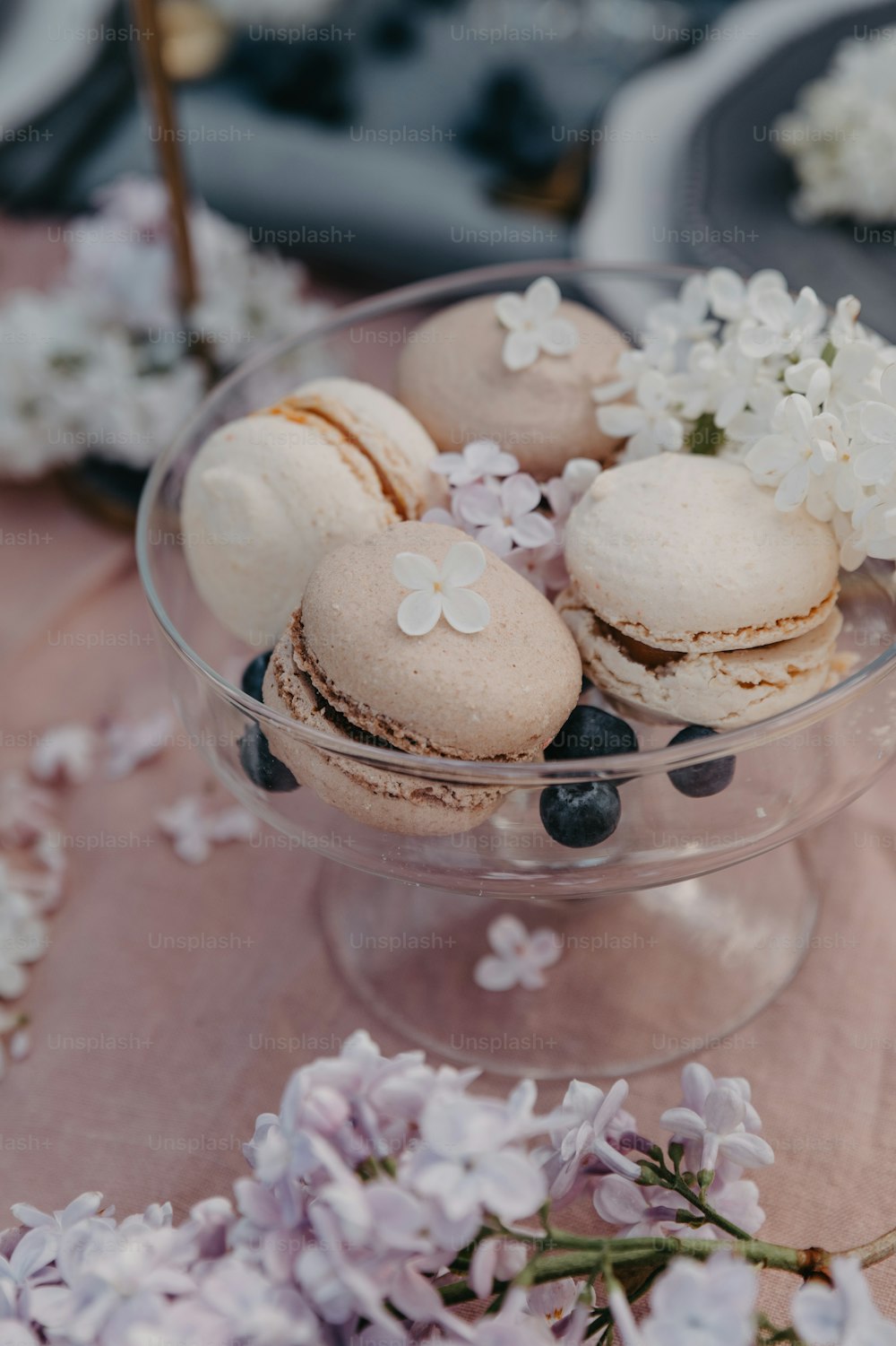 a glass bowl filled with macaroons and blueberries
