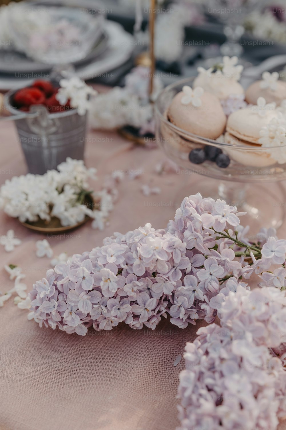 a close up of a table with flowers and desserts