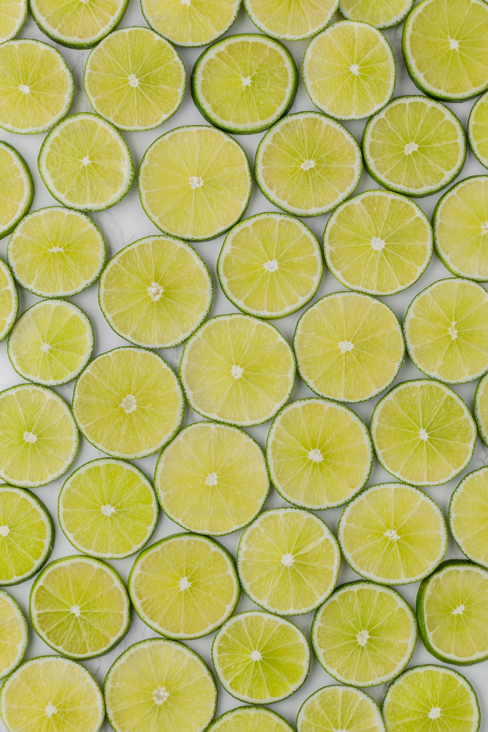 a group of limes cut in half on a white surface