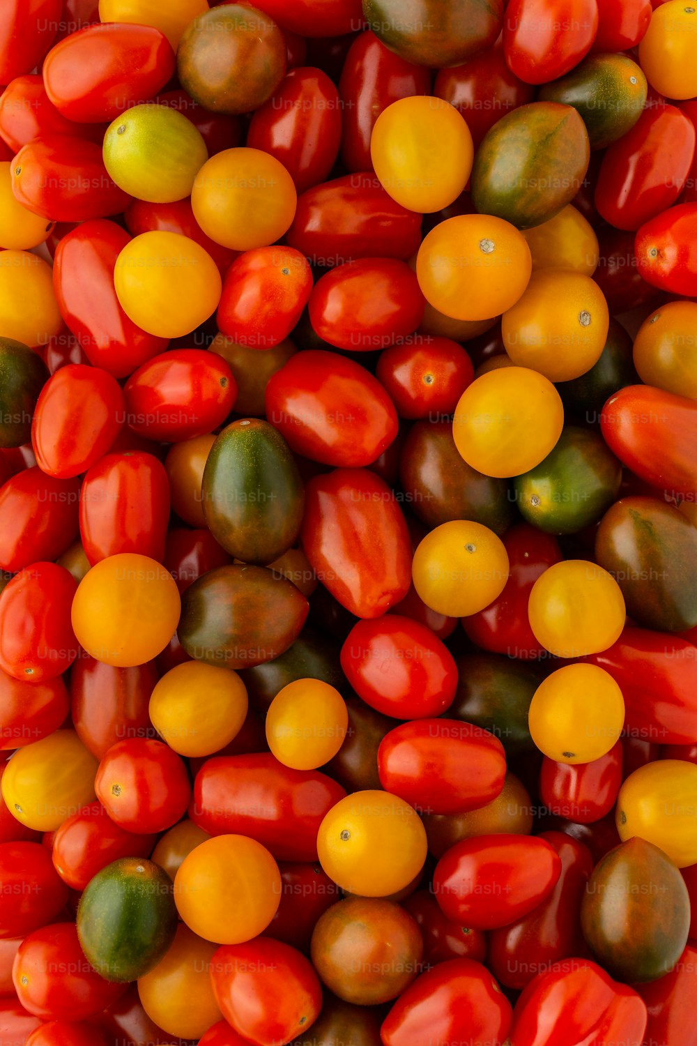 a large pile of tomatoes and oranges