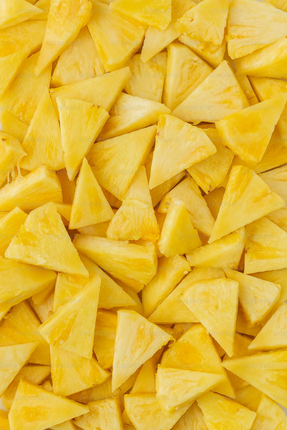 a pile of cut up pineapples sitting on top of a table