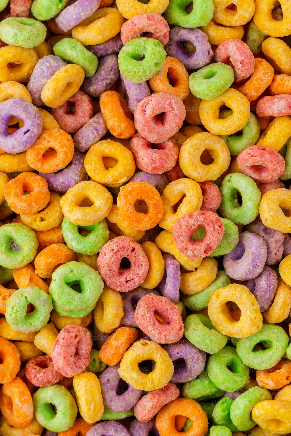 uma pilha de donuts multicoloridos sentados um ao lado do outro
