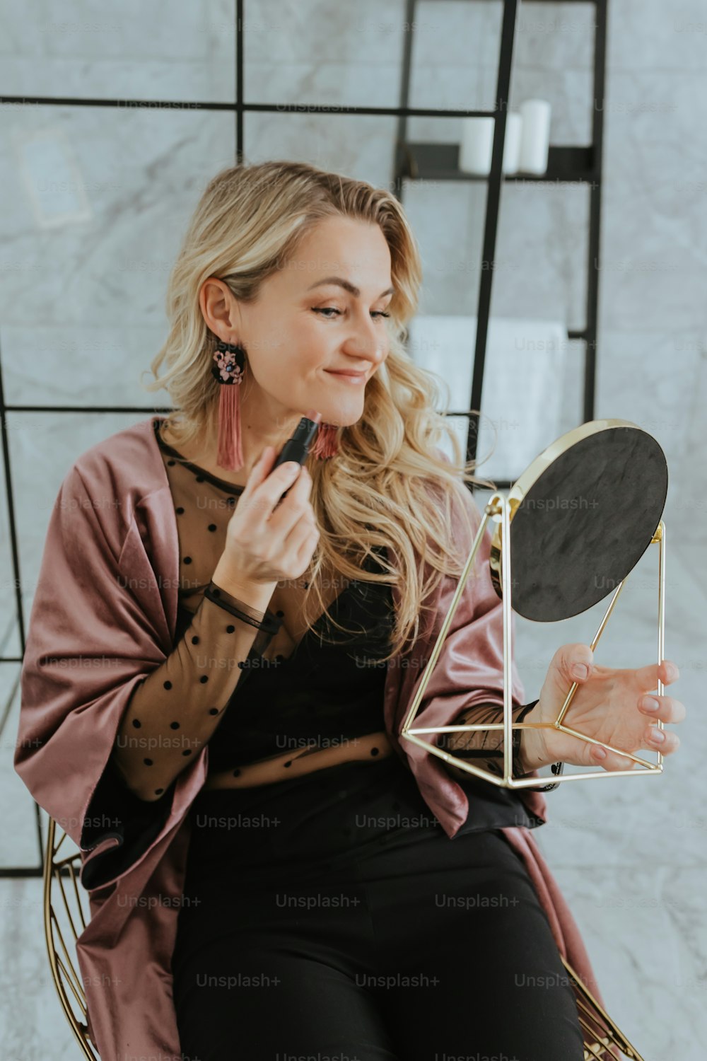 a woman sitting in a chair holding a mirror