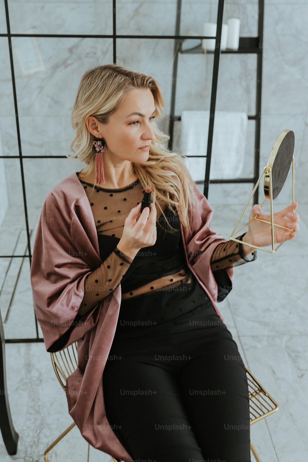 a woman sitting in a chair holding a mirror