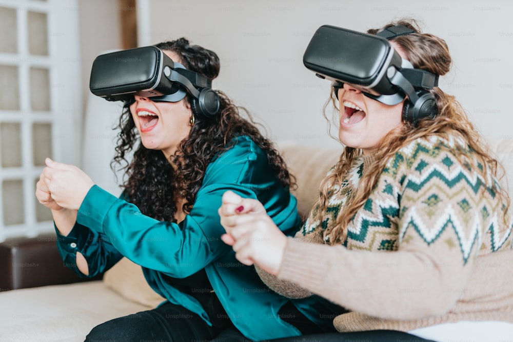 two women sitting on a couch wearing virtual headsets