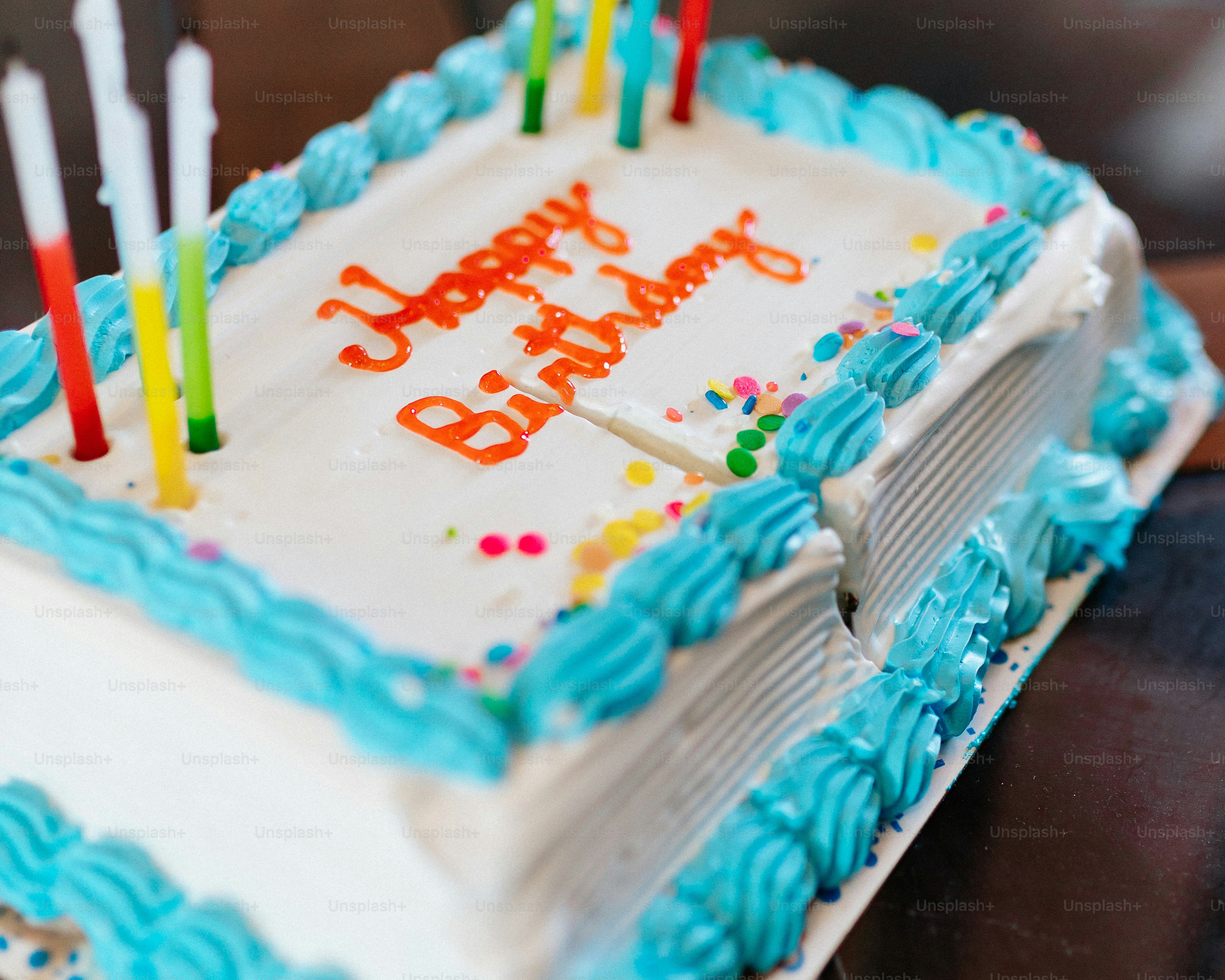 A birthday cake with blue frosting and lit candles photo – Birthday