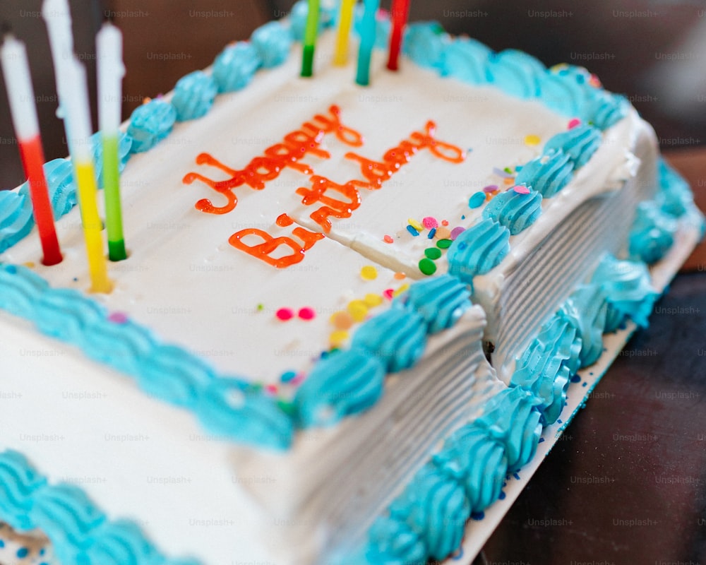 a birthday cake with blue frosting and lit candles