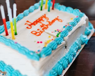 Un pastel de cumpleaños con glaseado azul y velas encendidas