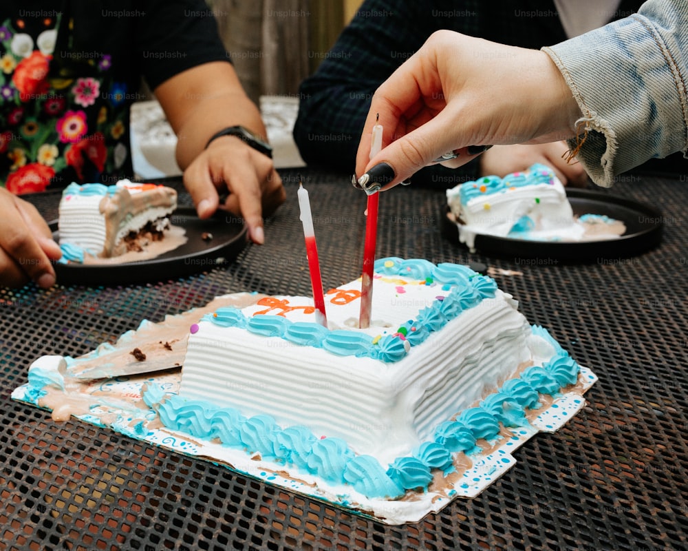 a person lighting candles on a cake on a table