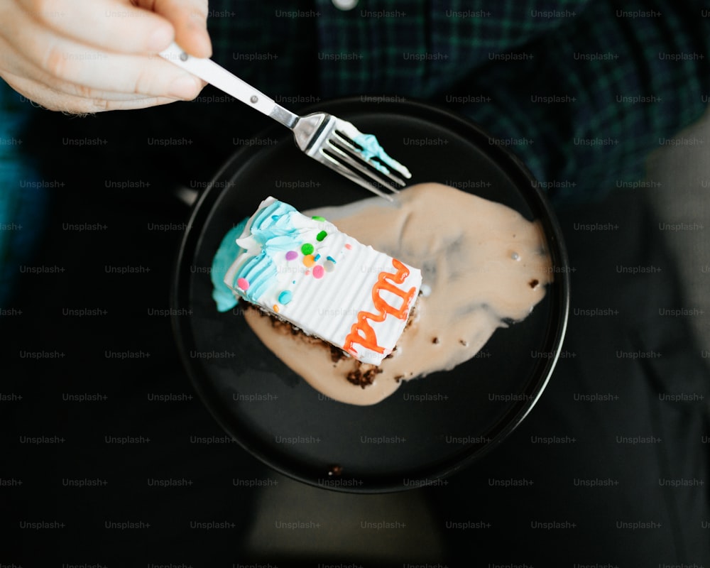 a person holding a fork and a piece of cake