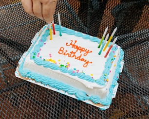 Una persona sosteniendo un pastel de cumpleaños con velas