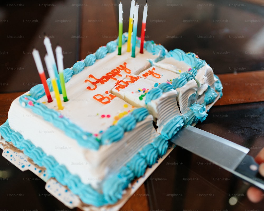 um bolo de aniversário com velas acesas em uma mesa