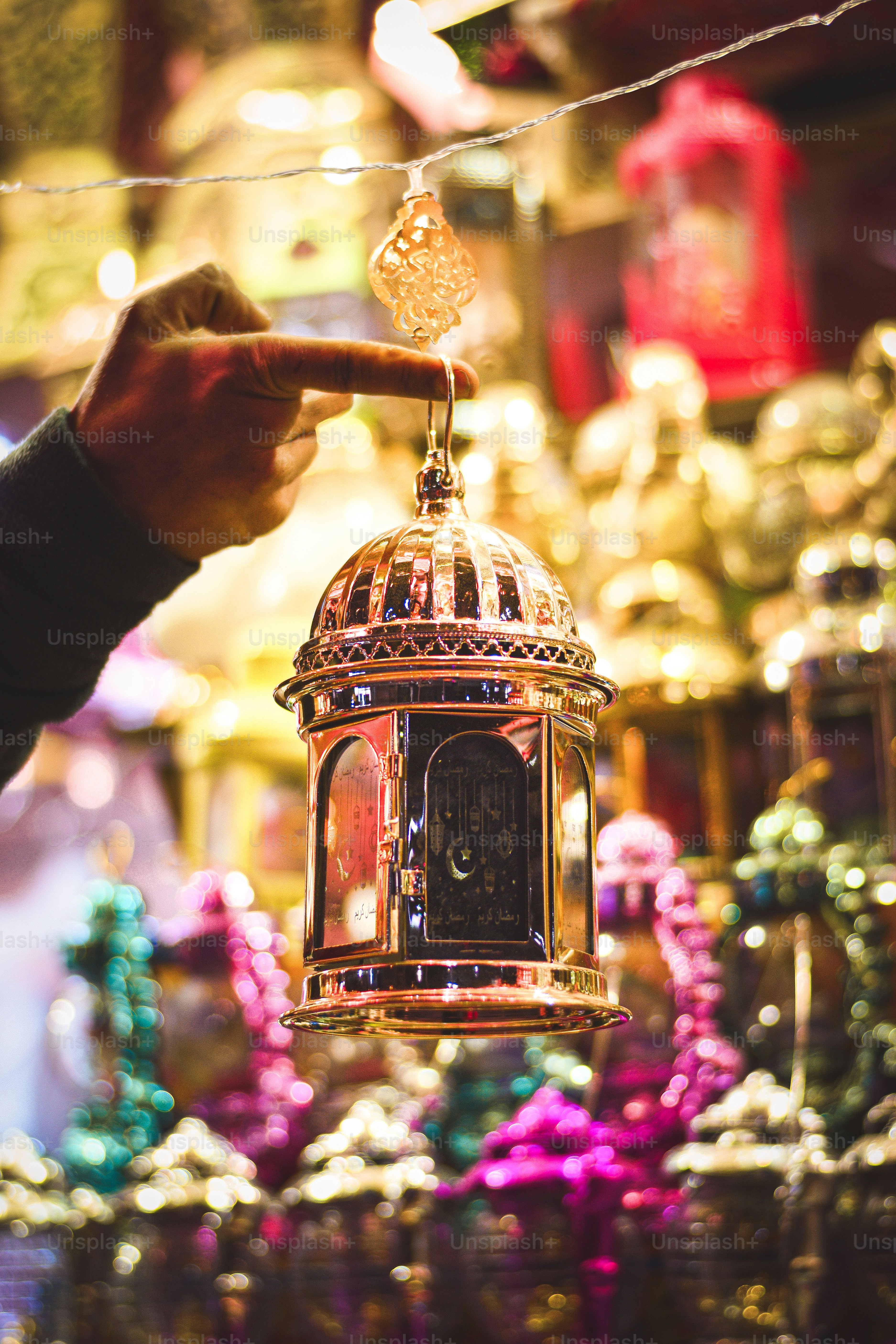 a person pointing at a small clock on a string