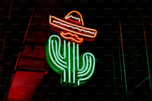 a neon sign with a taco and a hat on top of it